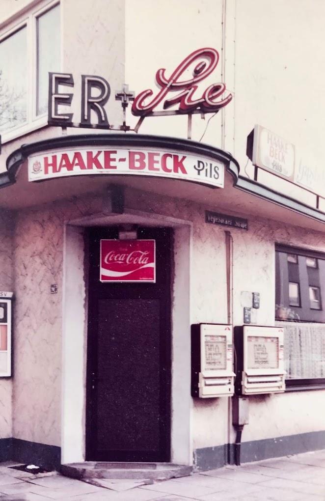 Die alte Leuchtreklame des Er & Sie mit Cursive-Schriftzug, HAAKE-BECK Pils Werbung und Coca-Cola Türschild — vermutlich 1980er Jahre